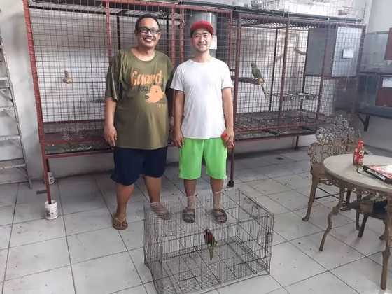 A happy family with the parrot they took home from Mysher Aviary